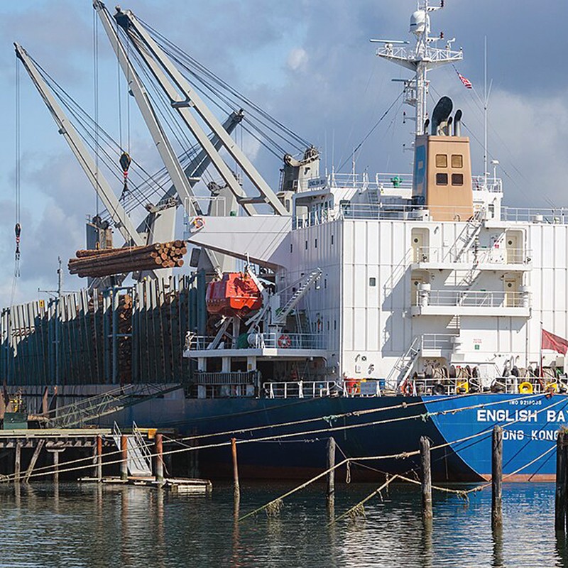 A ship is loaded with logs for export at the port on Coos Bay in North Bend. Coos County. Oregon State Archives. Wikimedia Commons.